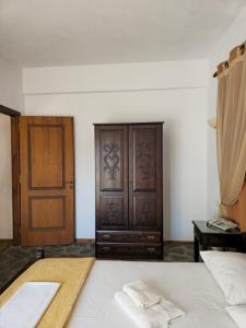 a bedroom with a bed and a wooden cabinet at Amalthia hotel 