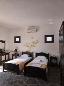 a room with two beds and a table at Amalthia hotel in Límni