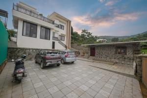 two cars parked in a parking lot in front of a house at 5BHK Villa With Pool & Theater Room in Malavli