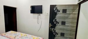 a room with a door with a tv on the wall at Sakshi Seva Sadan Vrindavan Homestay & Restaurant in Vrindāvan