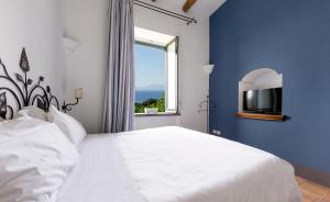 a bedroom with a white bed and a window at Relais Regina Giovanna in Sorrento