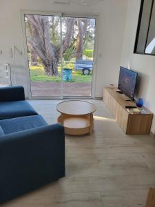 un salon avec un canapé bleu et une table dans l'établissement Belle Villa Neuve 4 étoiles, à La Celle-sous-Gouzon