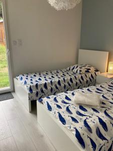 une chambre avec deux lits avec des draps bleus et blancs dans l'établissement Belle Villa Neuve 4 étoiles, à La Celle-sous-Gouzon