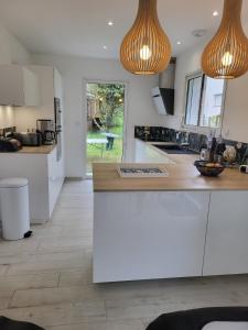 une cuisine avec des armoires blanches et un comptoir dans l'établissement Belle Villa Neuve 4 étoiles, à La Celle-sous-Gouzon