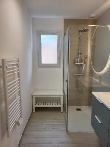 La salle de bains blanche est pourvue d'une douche et d'une fenêtre. dans l'établissement Belle Villa Neuve 4 étoiles, à La Celle-sous-Gouzon