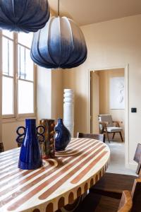 NoChichi-Collections - Place des Vosges في باريس: غرفة طعام مع مزهريات زرقاء على طاولة