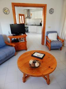 a living room with a table and a tv at Villa Carfax in Orba