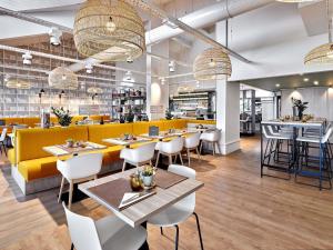 a restaurant with tables and chairs and a bar at ibis Styles La Roche-sur-Yon in Mouilleron-le-Captif