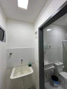 a white bathroom with a sink and a toilet at WT Corais Flats in Maragogi +67 photos