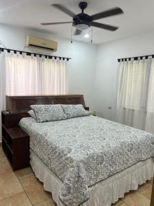 a bedroom with a bed and a ceiling fan at Buena ubicación para su visita en la ciudad y alrededores in Puerto Cortes