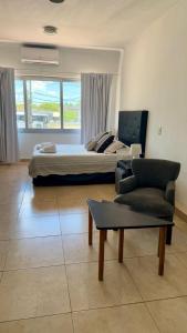 a bedroom with a bed and a couch and a chair at Punto Maschwitz Alquileres - Monoambiente in Ingeniero Maschwitz
