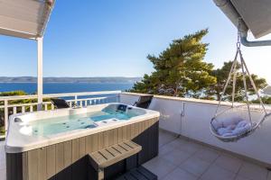 a hot tub on the balcony of a house at Villa ELLA ESTELLE with a heated pool, hot tub, sauna in Mimice