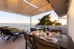 a table on a balcony with a view of the water at Villa ELLA ESTELLE with a heated pool, hot tub, sauna in Mimice