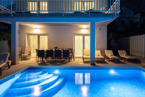 a swimming pool with a table and chairs next to it at Villa ELLA ESTELLE with a heated pool, hot tub, sauna in Mimice +36 photos