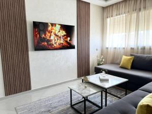 盖尼特拉Nouvel Appartement Confortable Avec Netflix & IPTV的客厅配有沙发和墙上的壁炉