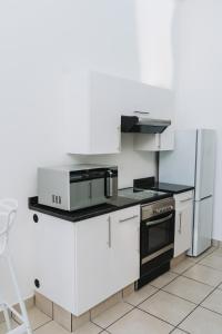 a white kitchen with a stove and a refrigerator at Ihita unit 11 in Sandton