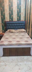 a bed with a blue headboard in a bedroom at Hotel Om in Jaunpur +7 photos