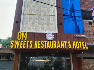 a sign that reads om sweets restaurant and hotel at Hotel Om in Jaunpur