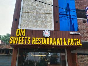 a sign that reads om sweets restaurant and hotel at Hotel Om in Jaunpur