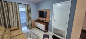 a living room with a television and a couch at MM Apart Premium Joinville in Joinville