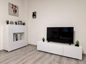 a living room with a flat screen tv on a white cabinet at Apartment-Topnik Datteln in Datteln