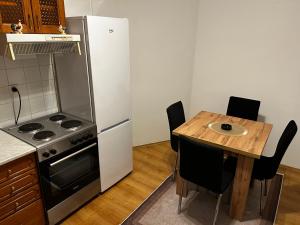 a kitchen with a table and a stove and a refrigerator at Mance apartments 2 in Paraćin