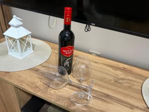 a bottle of wine sitting on a table with glasses at Mance apartments 2 in Paraćin