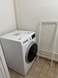 a washing machine in a laundry room with a cart at Flot 3 værelses lejlighed - op til 6 personer in Randers