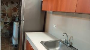 a small kitchen with a sink and a refrigerator at Alojamiento Independiente vipasa in Cali