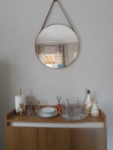 Un espejo encima de un armario de madera con platos. en cantinhodosocego, en Socorro 25 fotos más