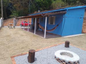 una casa azul con una hamaca delante en cantinhodosocego, en Socorro