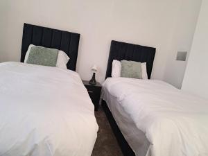deux lits côte à côte dans une chambre dans l'établissement Stretford Residence, à Manchester 8 autres photos