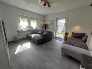 a living room with a couch and a bed at Fewo Erdgeschoss Ankerplatz mit Sauna direkt am Brombachsee bei Juliane und Klaus in Ramsberg +26 photos