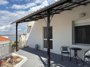 une pergola sur un balcon avec une table et des chaises dans l'établissement The White House - Aianteio, à Aiándion