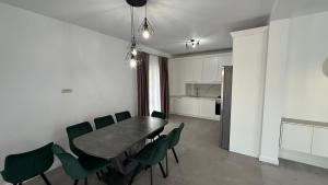 a dining room with a table and green chairs at Stylish House in Suceava
