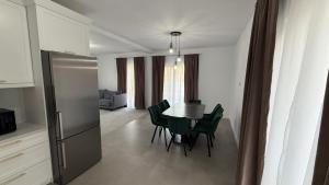 a kitchen and dining room with a table and green chairs at Stylish House in Suceava