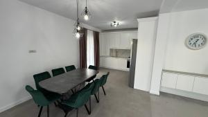 a dining room with a table and green chairs at Stylish House in Suceava