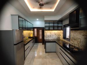 a large kitchen with black counters and stainless steel appliances at Pushp-Raj in Jodhpur