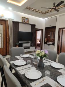 a dining room with a table with chairs and a television at Pushp-Raj in Jodhpur