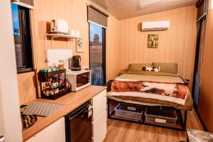 a small bedroom with a bed in a trailer at Hermano Farm Stay by Tiny Away in Greenhills +41 photos