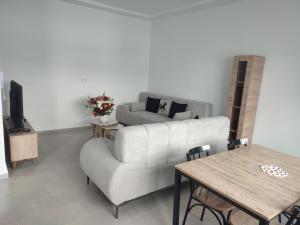 una sala de estar con un sofá y una mesa en Studio en rez de jardin, en Hammamet