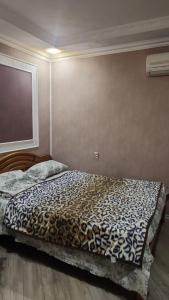 een bed in een slaapkamer met een luipaardprint deken bij Comfort Apartment Near Staidum in Ganja +4 foto's