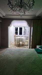een eetkamer met een tafel en een kroonluchter bij Comfort Apartment Near Staidum in Ganja