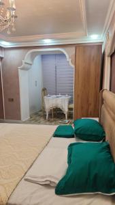 een kamer met een bed met groene kussens en een tafel bij Comfort Apartment Near Staidum in Ganja