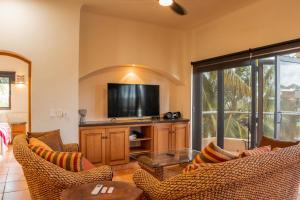 a living room with couches and a flat screen tv at Playa Grande Condominium in El Coco