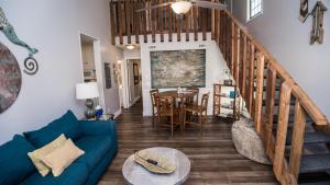 un salon avec un canapé bleu et un escalier dans l'établissement Horizon South 33D - Sunstead Retreat - Sleeps 6, à Panama City Beach