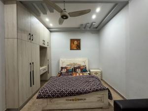 een slaapkamer met een bed en een plafondventilator bij 1 bed apartment in Rawalpindi
