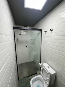 een badkamer met toilet en glazen douche bij Apartmento aconchegante no centro da capital in Brasilia