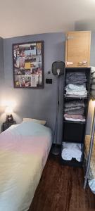 1 dormitorio con cama y estante con ropa en Bed in a small dormitory 13m2 of 5 beds in sharing flat, en Le Kremlin-Bicêtre