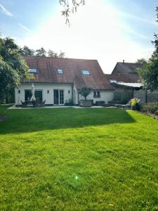 a house with a large lawn in front of it at Boutique Stay with Bath & Garden near Ghent in Sint-Martens-Latem